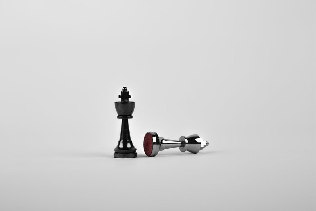 A chess pawn topples another one, symbolizing the replacing of a debtor's management with a chapter 11 trustee