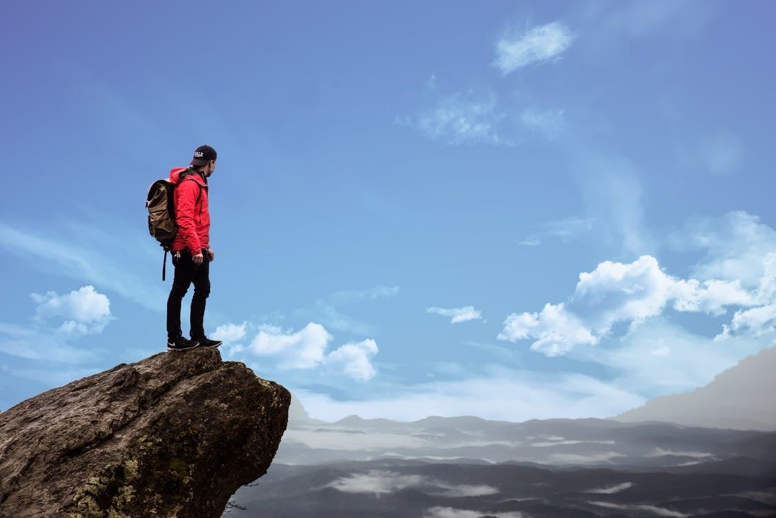 A rock climber looks over a precipice, symbolizing investors overcoming their fear of filing an involuntary bankruptcy petition